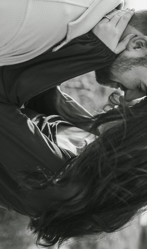 Artistic black and white close-up photo of couple in tender moment.