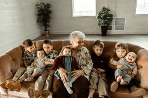 A cozy gathering on a brown sofa with multiple generations sharing warm moments together.