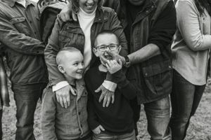 Black and white candid portrait of playful expressions during family photo shoot.