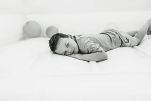 A resting child lies down on a soft white inflatable surface.