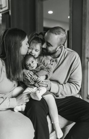 Intimate black and white family portrait showing tender moment of affection.