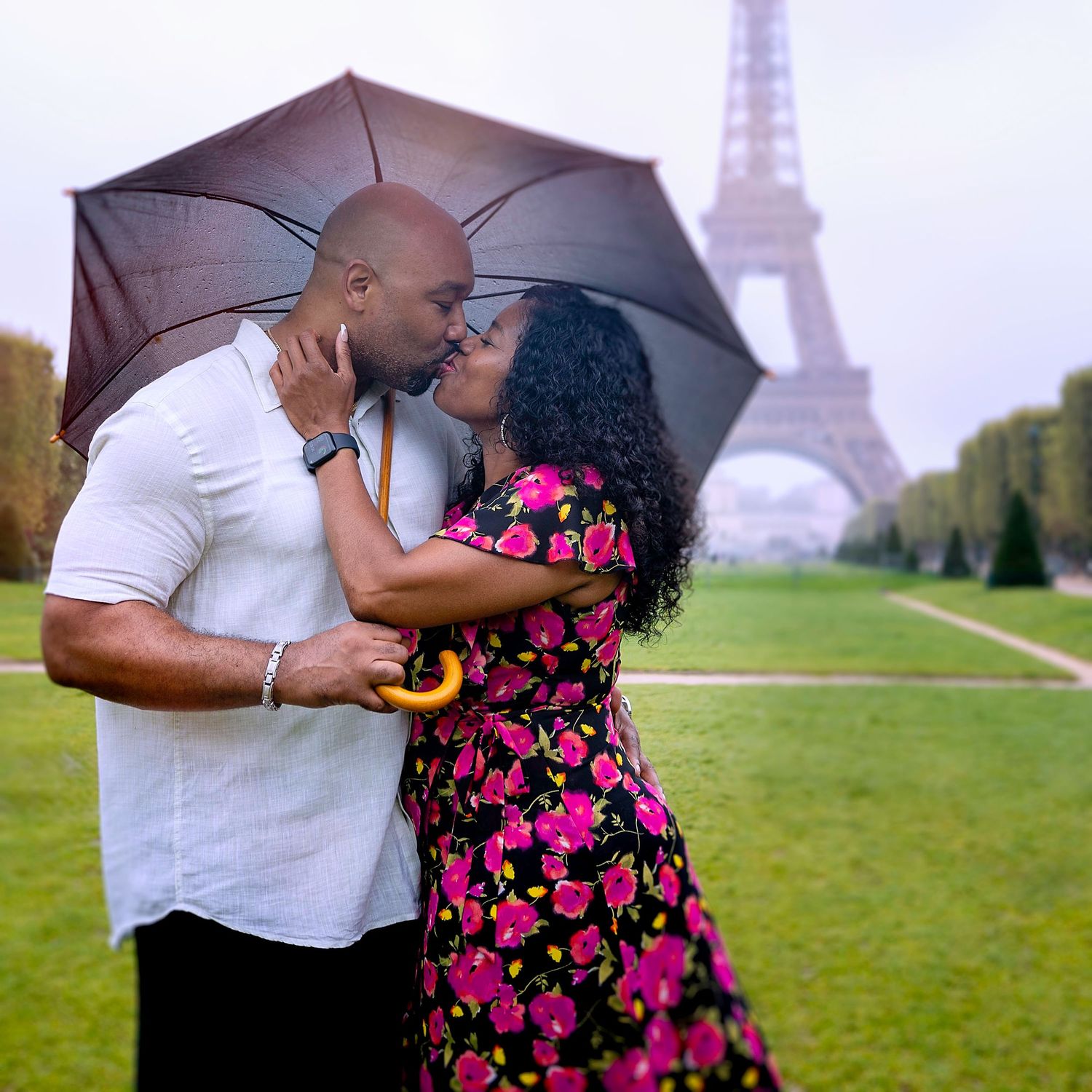 Black couple kissing in front of Eiffel Tower