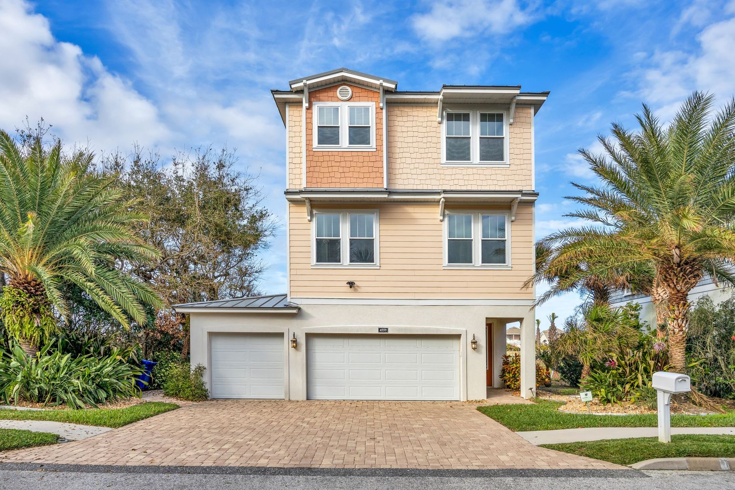 Front of a large yellow home with blue sky
