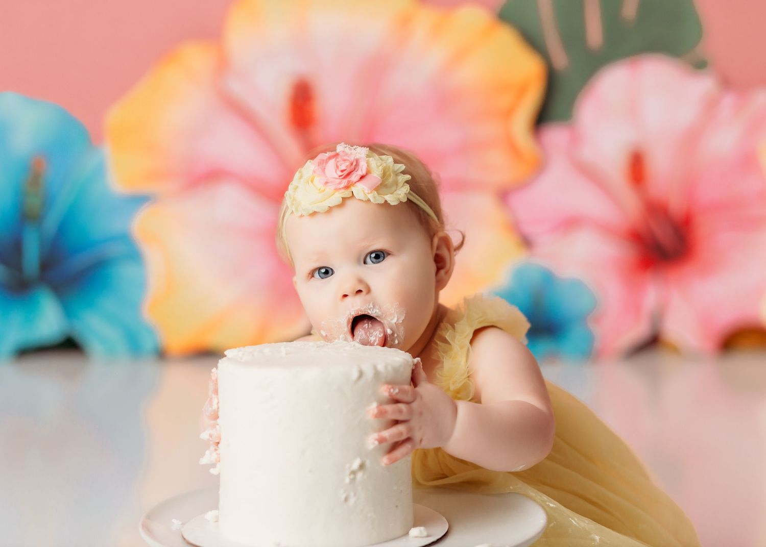 baby girl eating cake at her tropical theme cake smash in Broken Arrow, OK