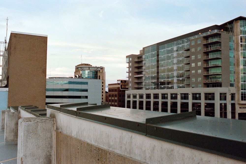 Modern urban apartment buildings and office structures viewed from a rooftop perspective.