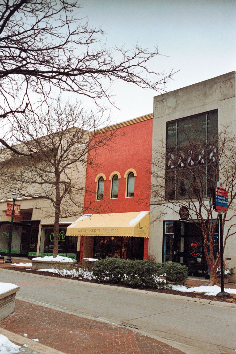 Historic brick buildings with arched windows on a snowy downtown street.