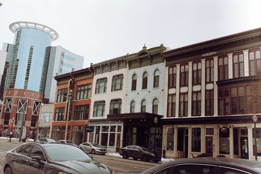 Mixed architectural styles of historic and modern buildings along a city street.