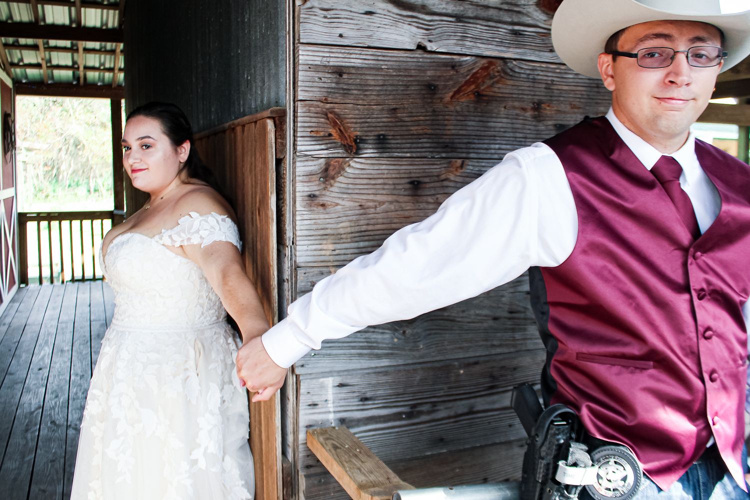 Creative wedding portrait on rustic wooden porch with burgundy and white attire.