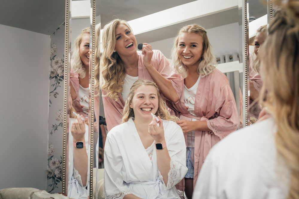 A cheerful scene reflected in bathroom mirrors with floral wallpaper visible.
