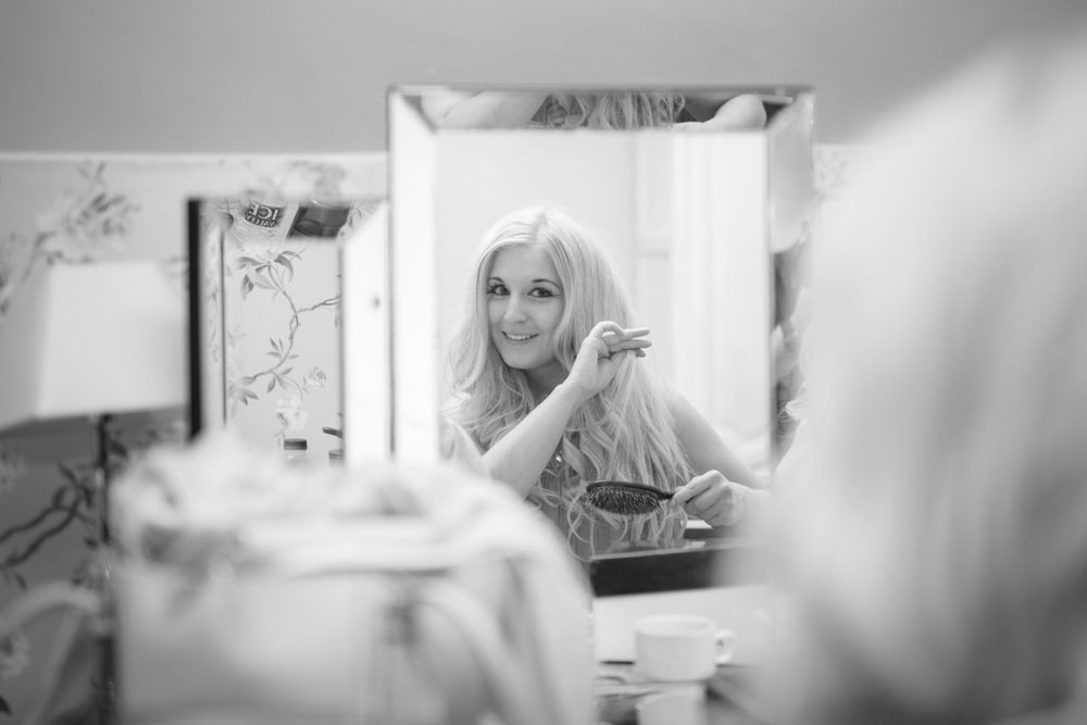 A black and white reflection captured in a vanity mirror showing preparation activities.