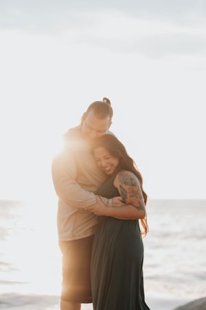 Tender sunset embrace between a couple on the beach.