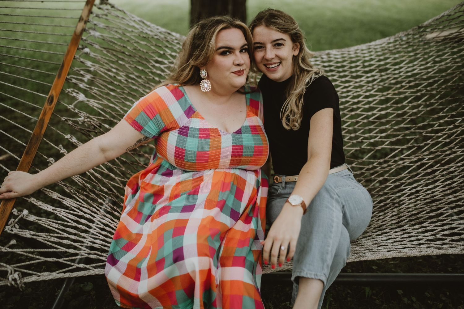 two girls smiling at camera on a hammock