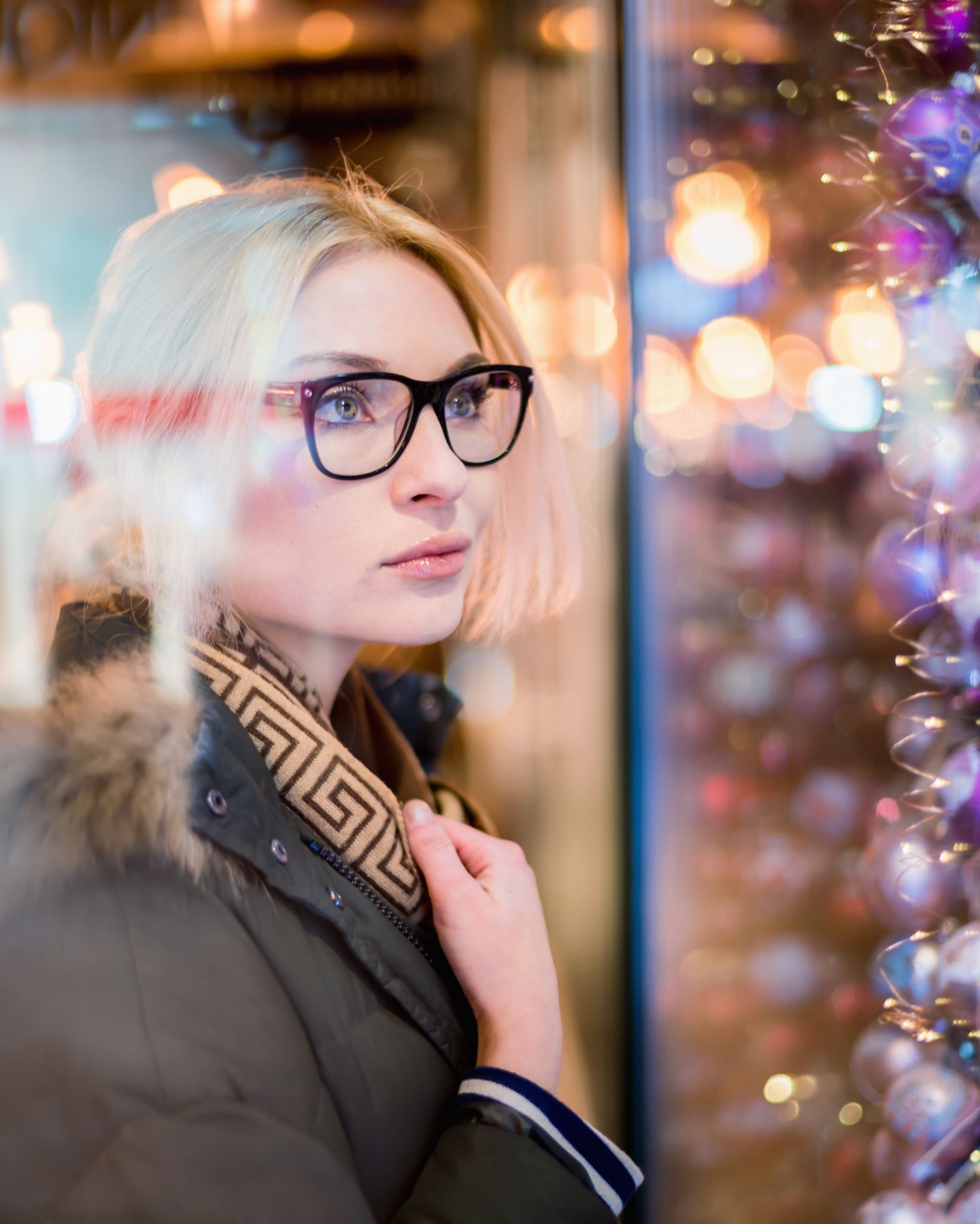 girl wearing glasses mesmerized by christmas lights and decorations at the budapest christmas markets