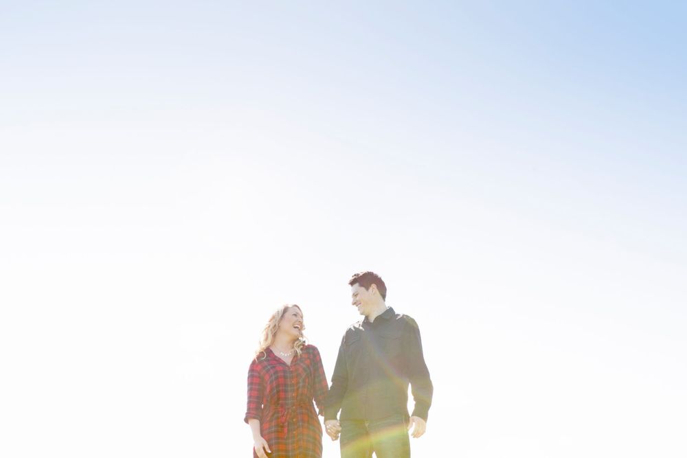 Iowa engagement photography by Sparrow and Bean Studio. Portrait of couple embracing in prairie at sunset.