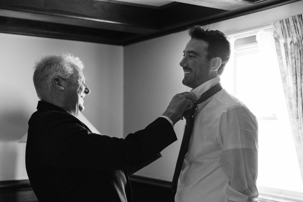 Black and white photo of final wedding preparation moments.