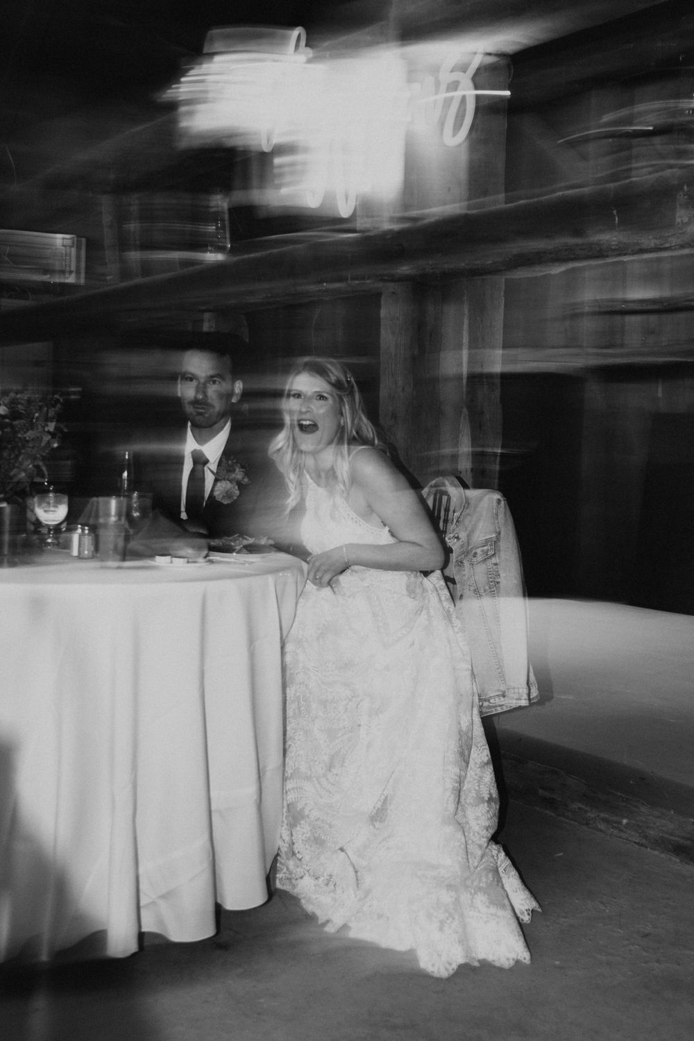 Artistic black and white motion blur capture of wedding reception celebration.