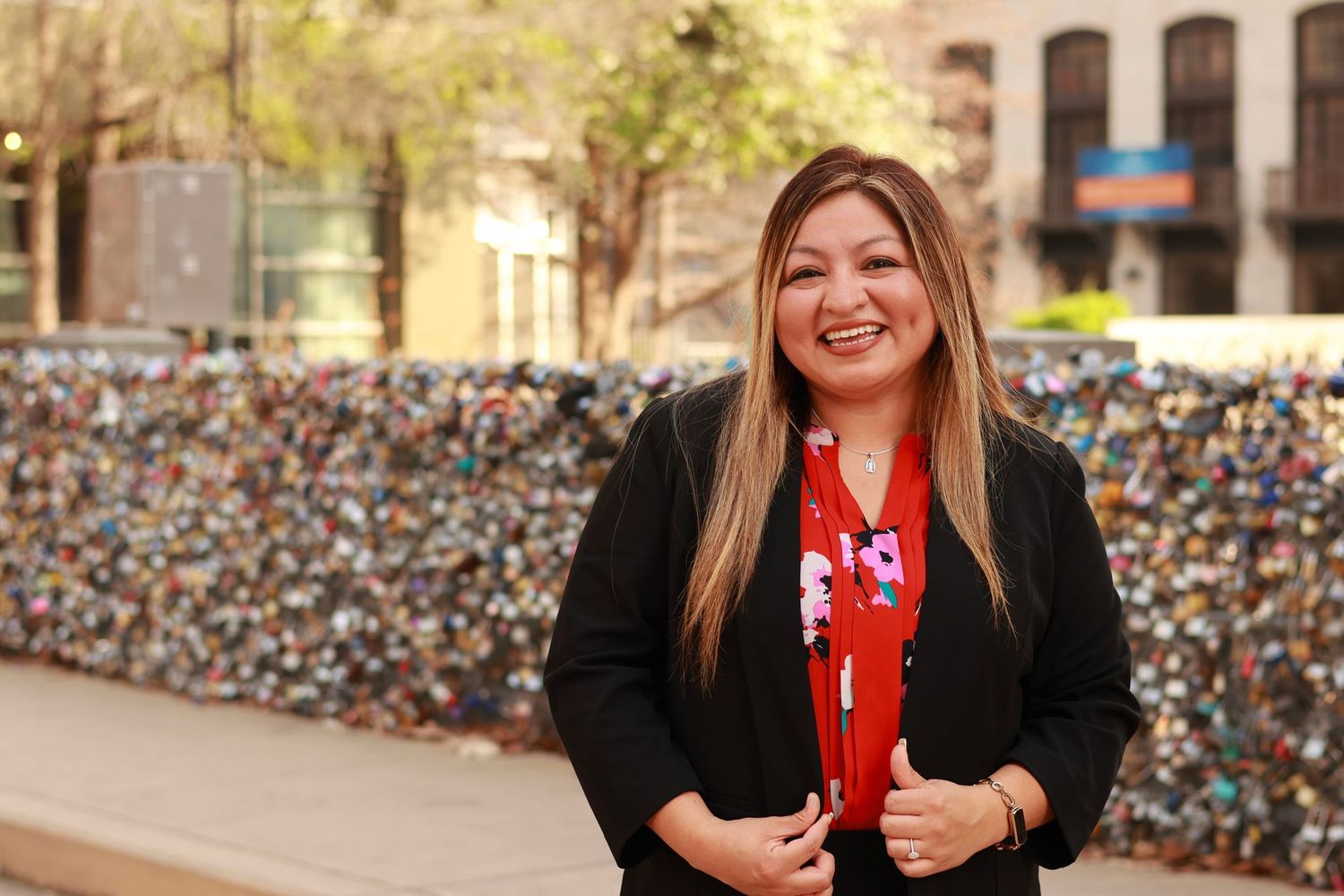 Professional portrait in front of a love lock wall.