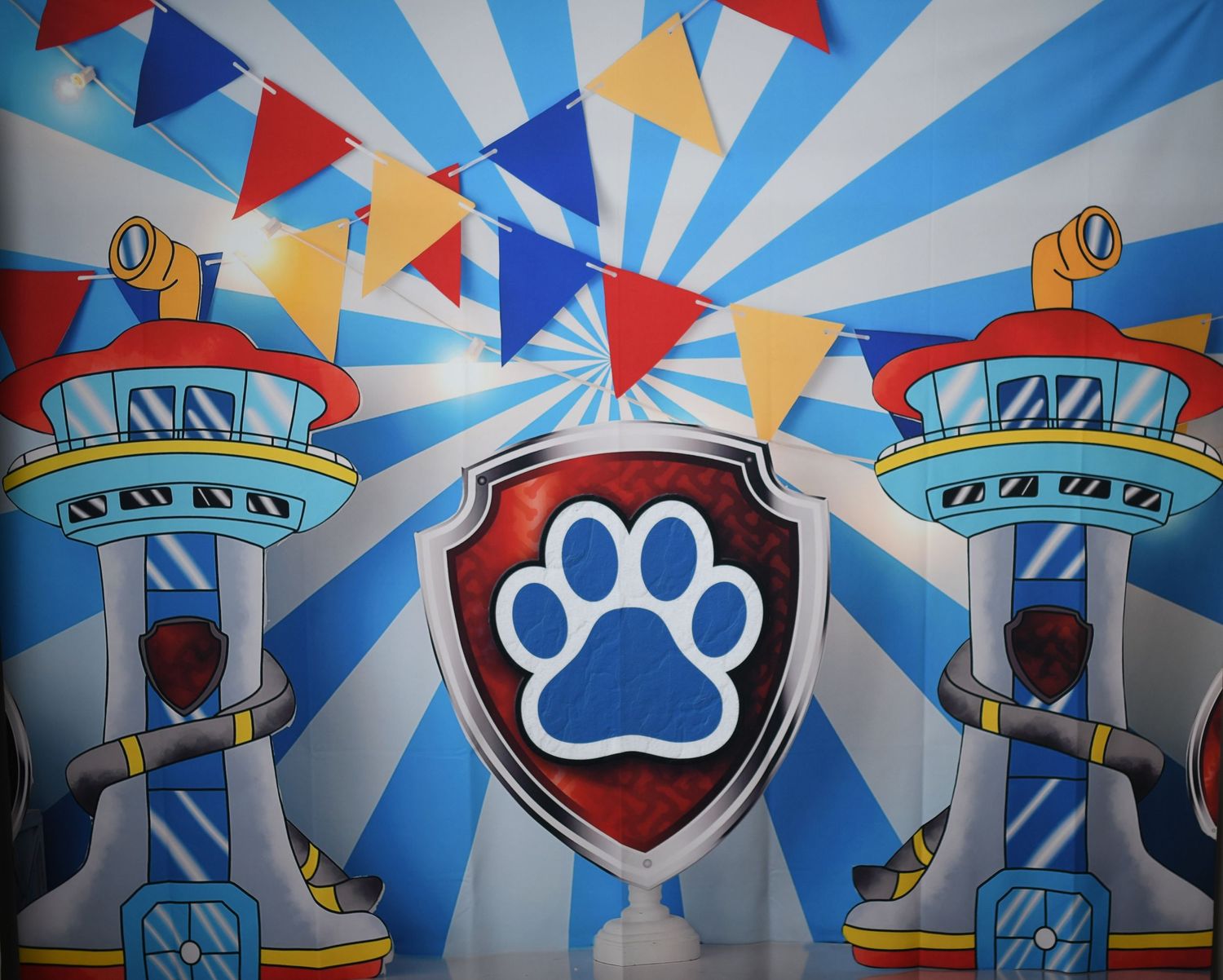 Colorful circus-themed backdrop with blue stripes, paw prints, and festive banners.
