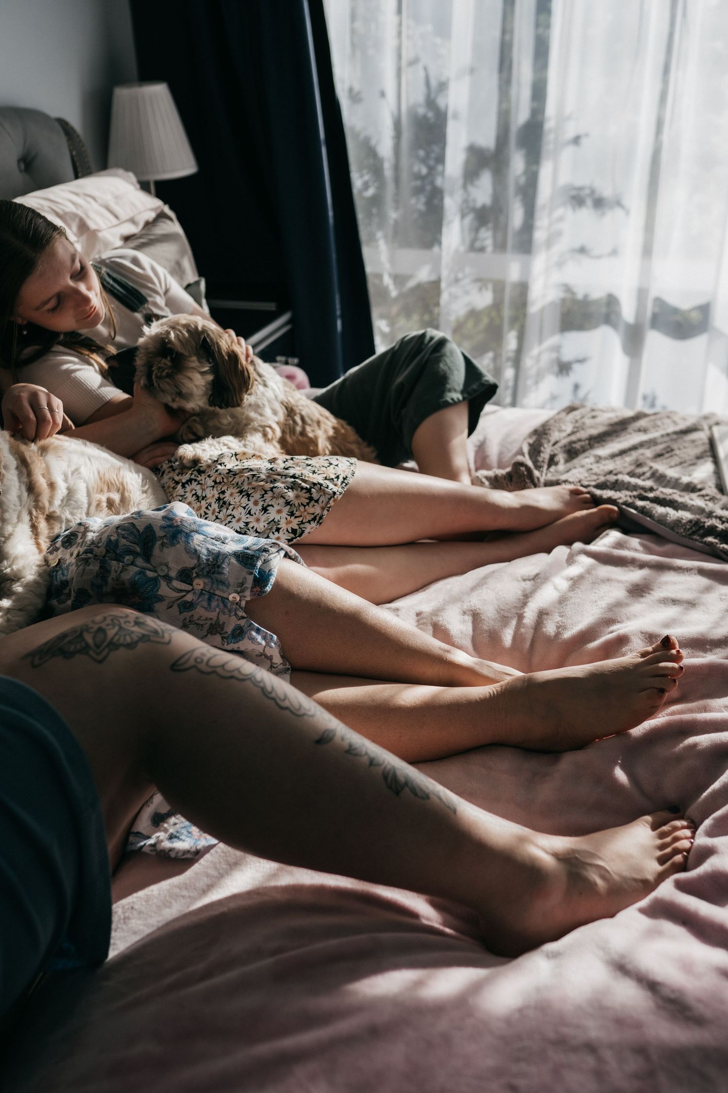 Mother and daughters relaxing on a bed with their dog
