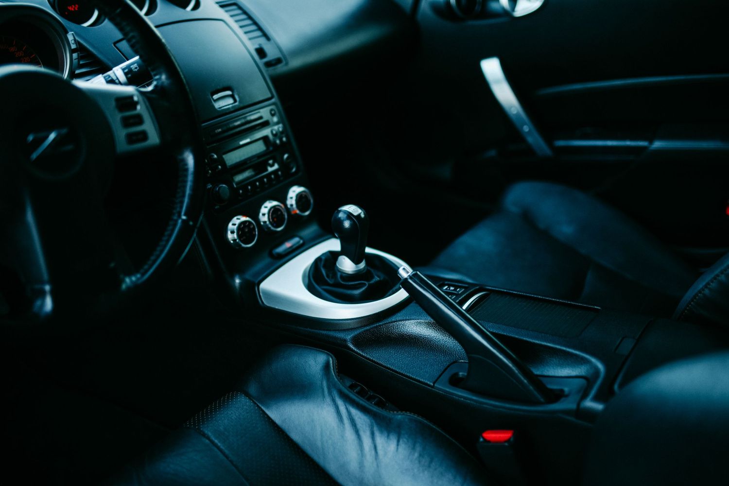 Dark interior of a sports car showing manual transmission shifter and center console controls.