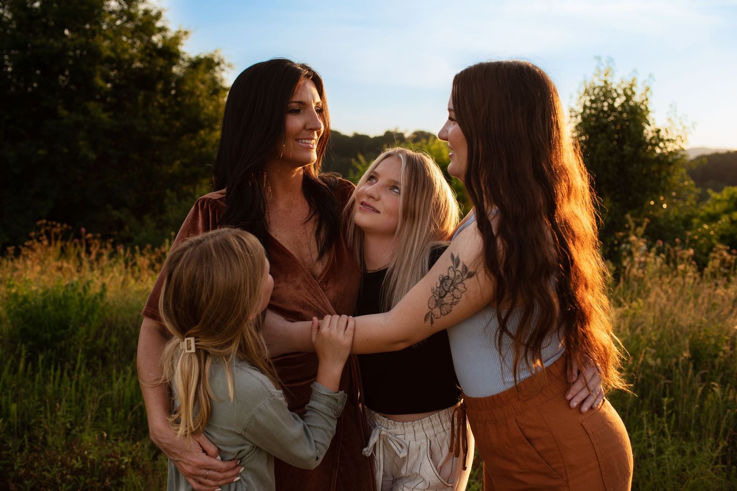 Mom and three daughters hugging