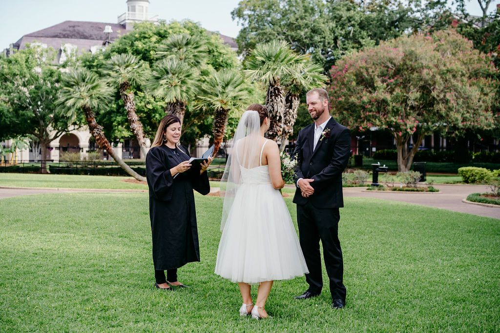 A couple reads their vows to each other while their officiant leads them with a script.