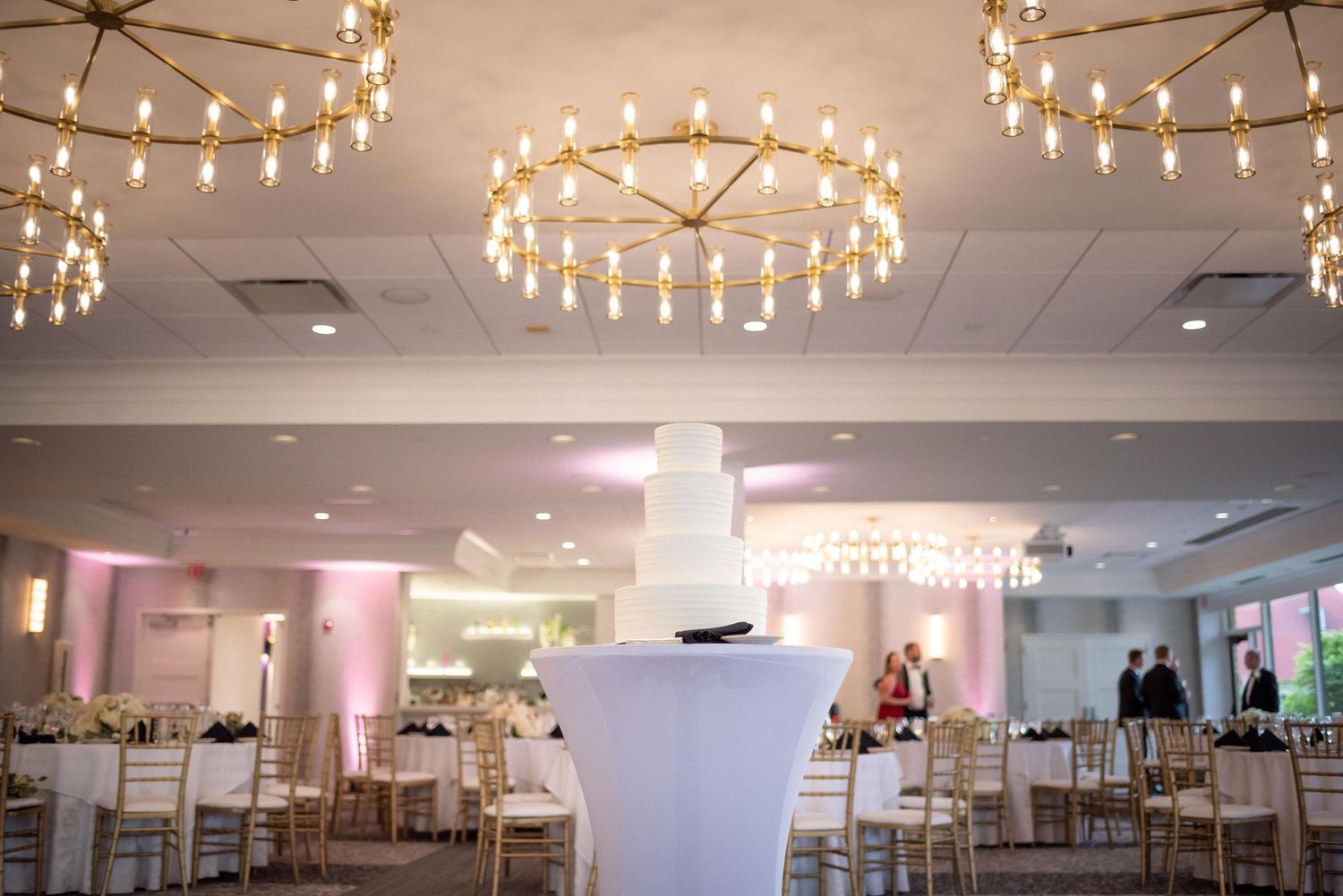 Wedding reception hall with string lights and chandeliers creating romantic ambiance.