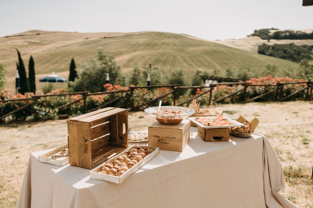 Rustic wooden wedding favor boxes displayed on table with rolling hills in background.