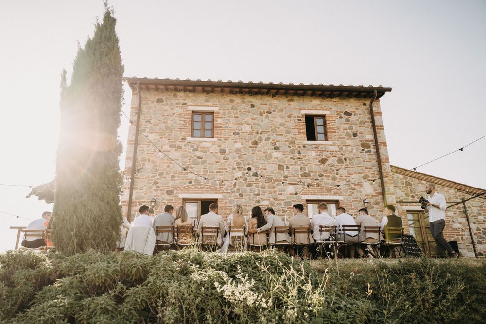 Stone villa wedding venue in Italian countryside with cypress trees and rustic architecture.