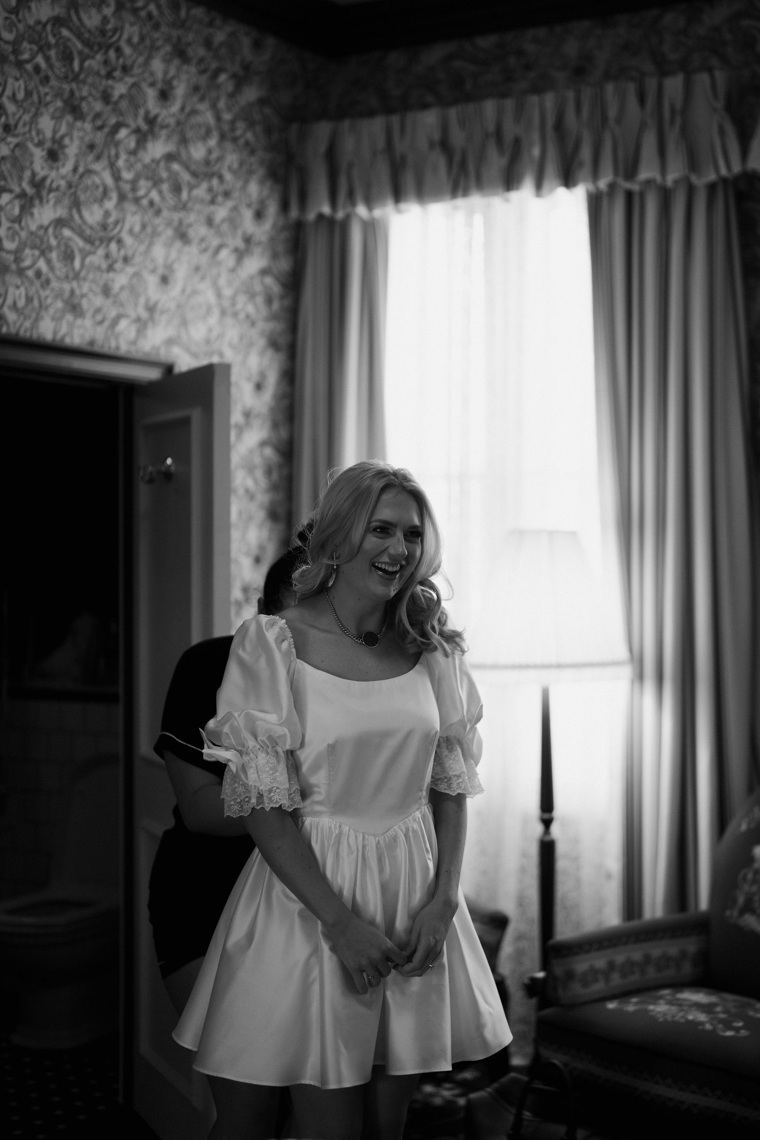 bridesmaid helping bride get in dress at the Randolph hotel in oxford
