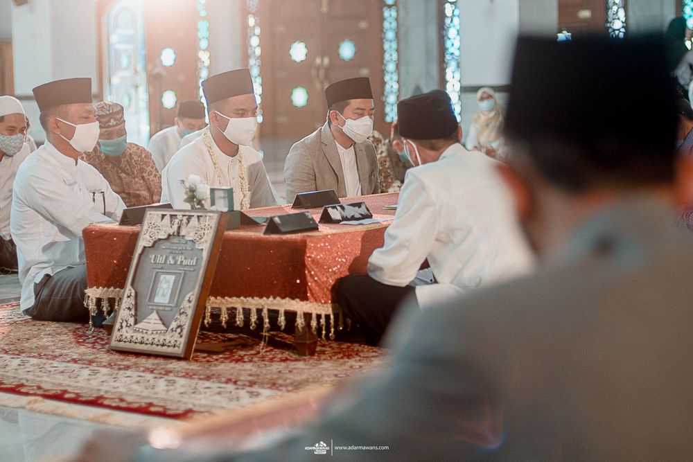 People gather around a table for a traditional Islamic ceremony in a mosque.