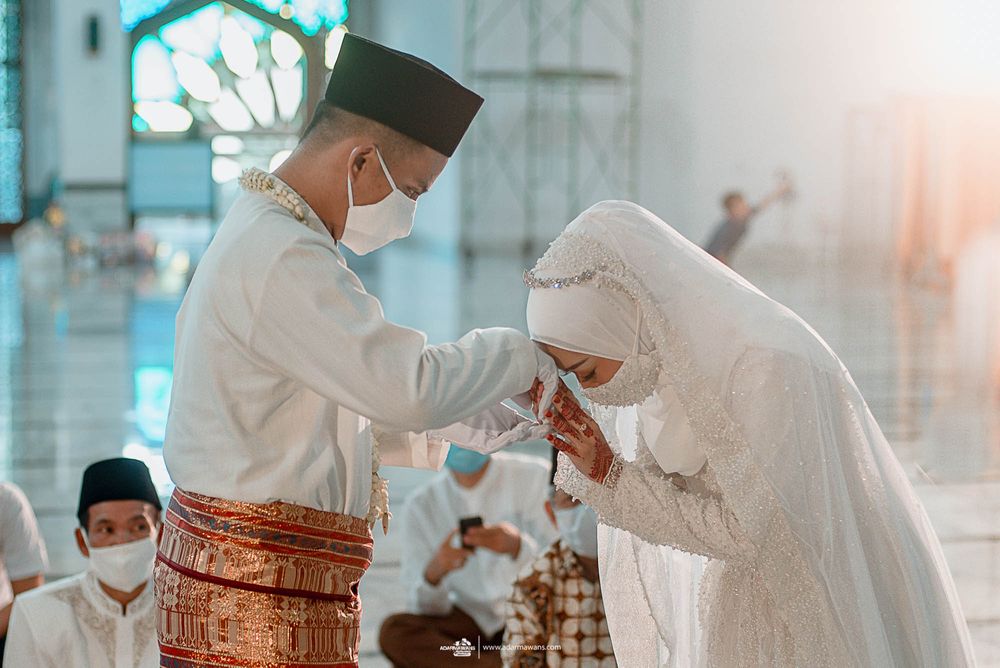Traditional Muslim wedding ceremony showing respectful greeting gesture.