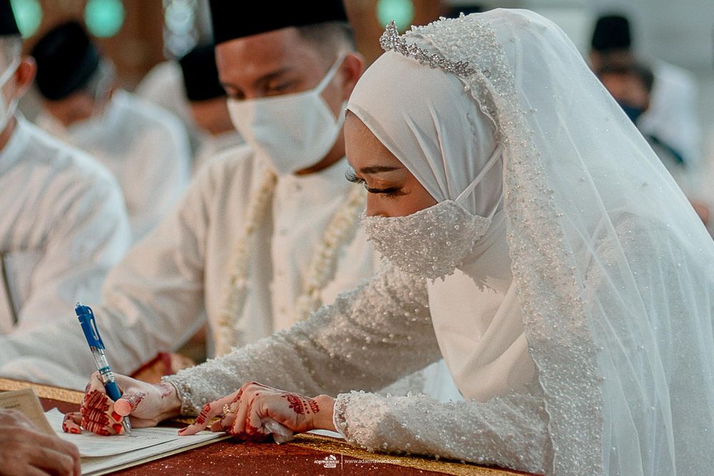 Signing of marriage documents during traditional Islamic wedding ceremony.