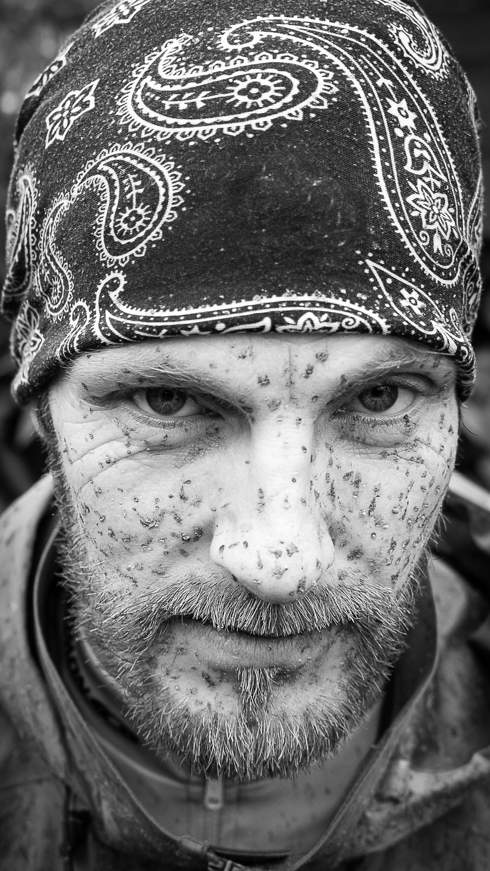 Zwart-wit portret van stoere mountainbiker met bandana en modderspetters na een MTB-rit – personal branding fotografie Arnhem
