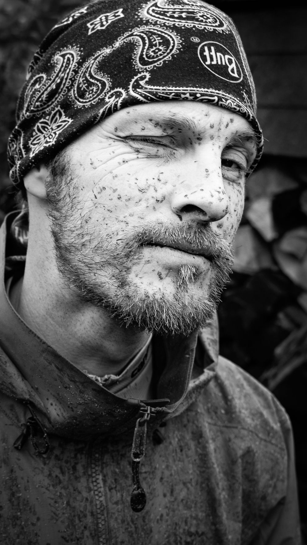 Stoer zwart-wit portret van mountainbiker met bandana en modderspetters – personal branding fotografie Arnhem