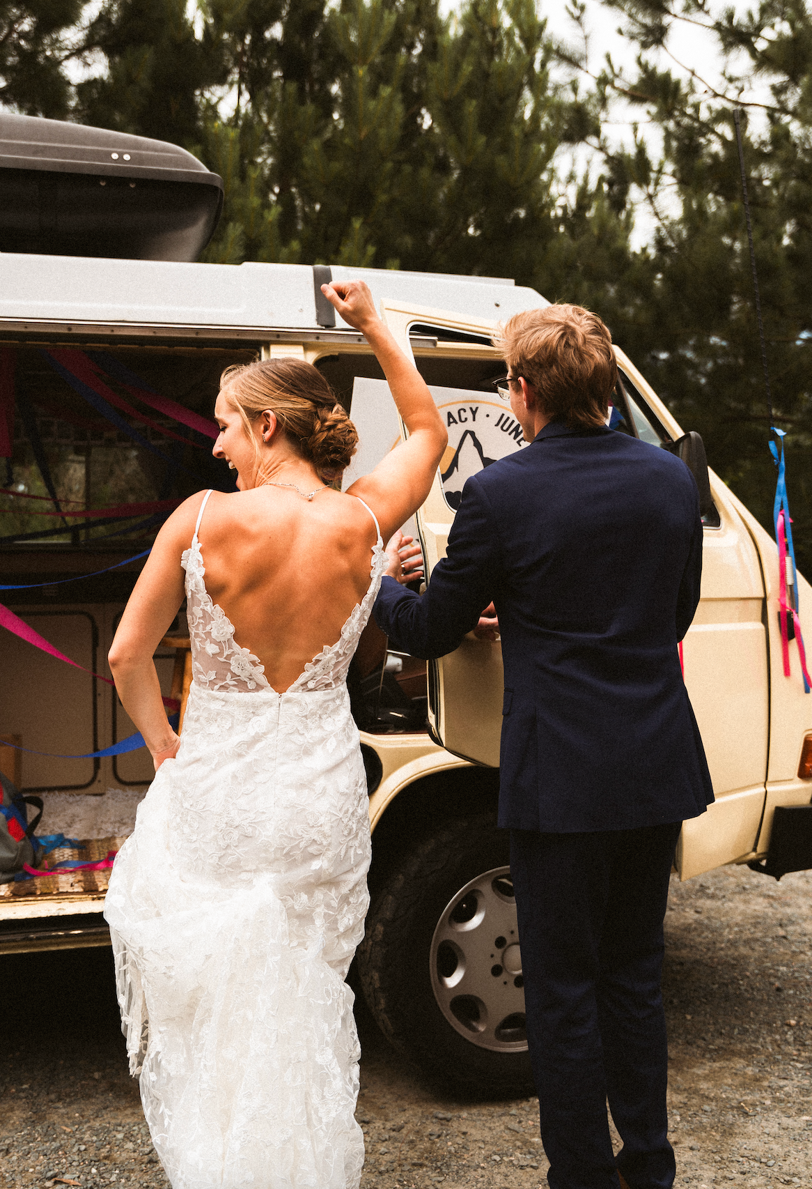 Newlyweds dancing by vintage van showing detailed lace back wedding dress.