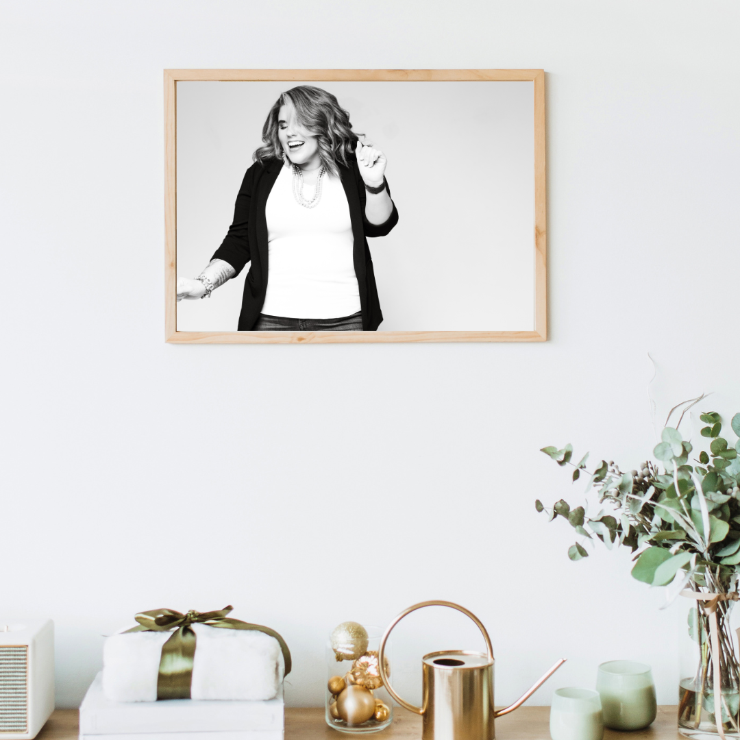 desk setting with black and white print of woman smiling and dancing above the desk