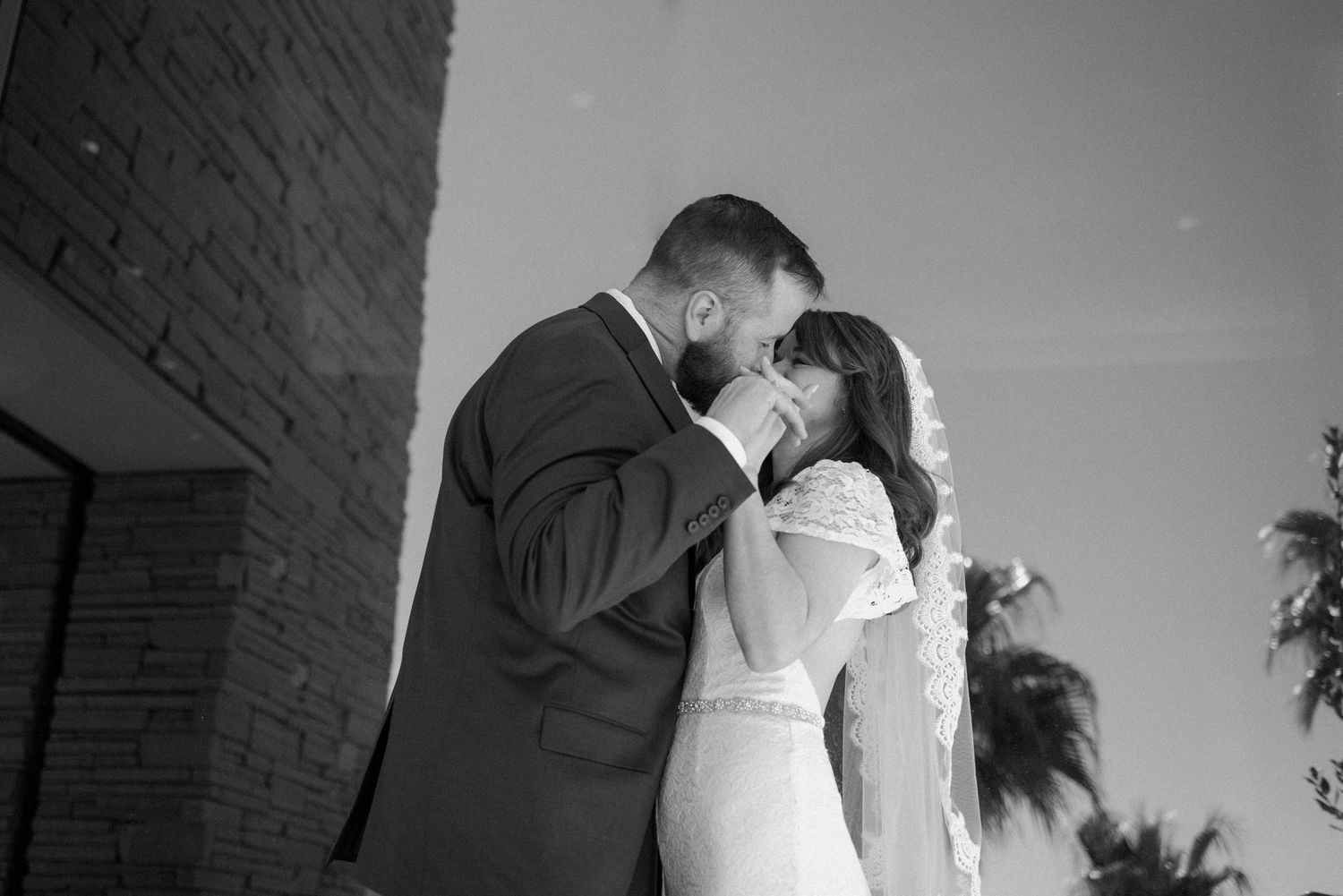 A romantic black and white portrait of a couple sharing an intimate moment on their wedding day.
