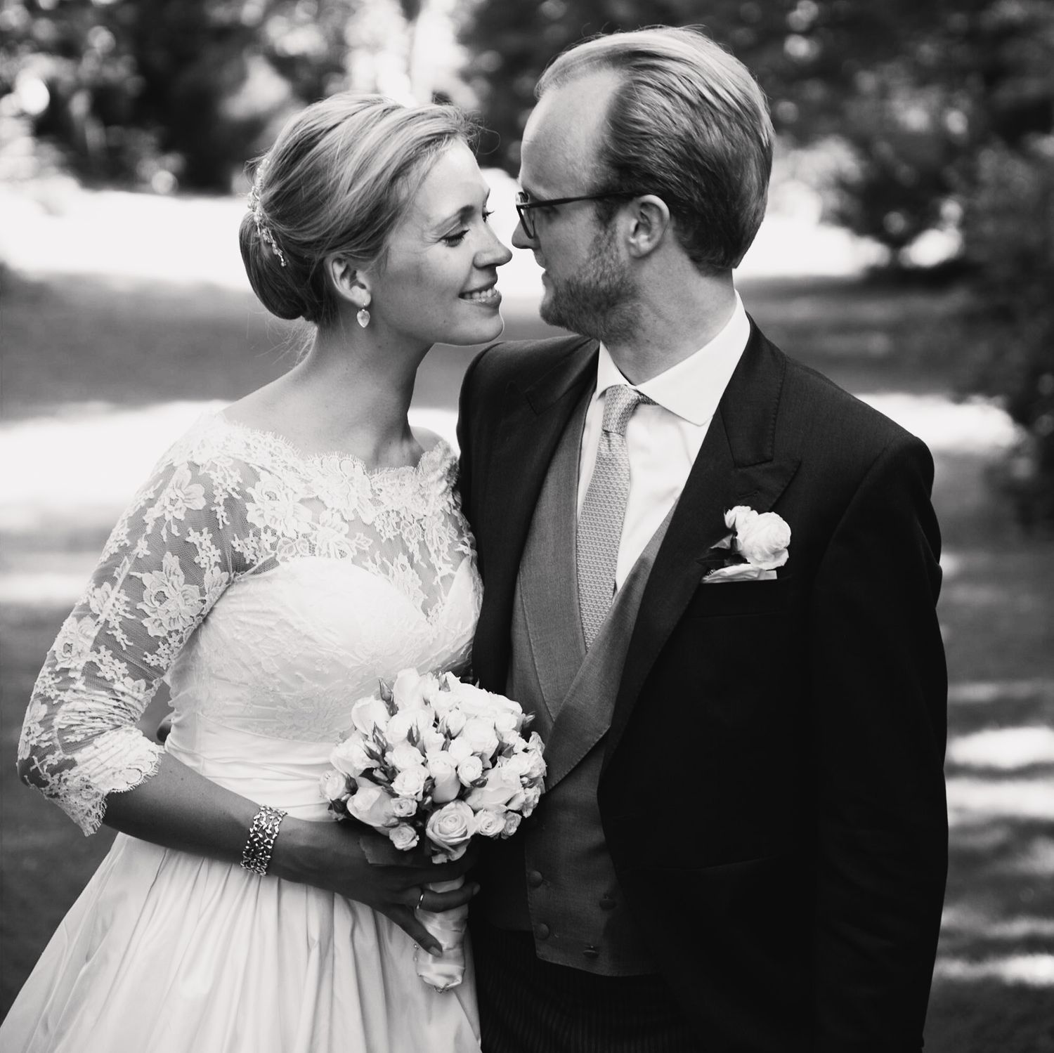 Wedding couple sharing tender moments outdoors in classic black and white photography.
