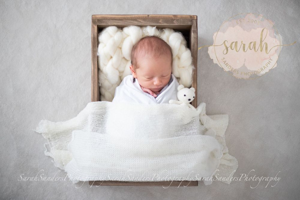 Newborn in a crate wrapped and posed