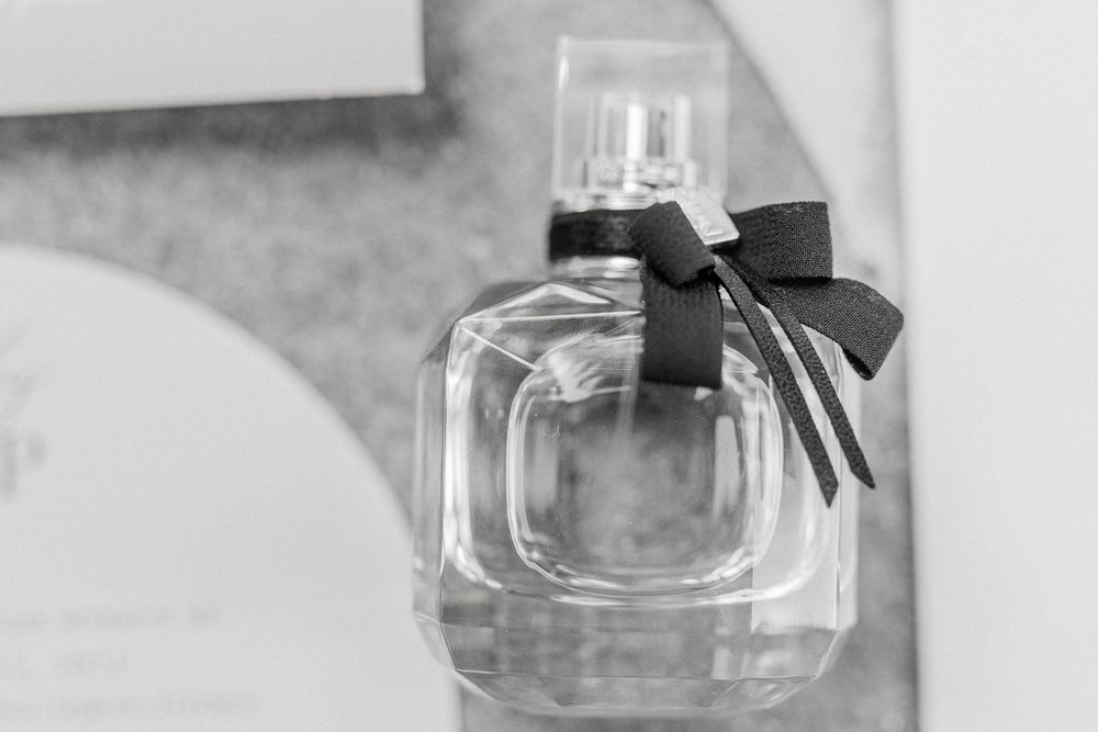 Elegant perfume bottle with black bow photographed in black and white.