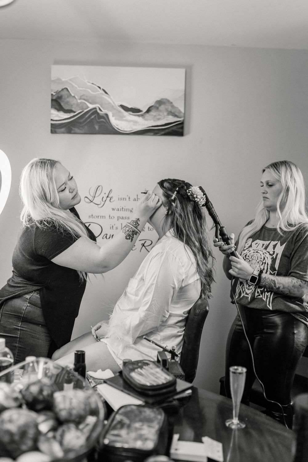 Professional makeup session in progress with beauty products visible on table.