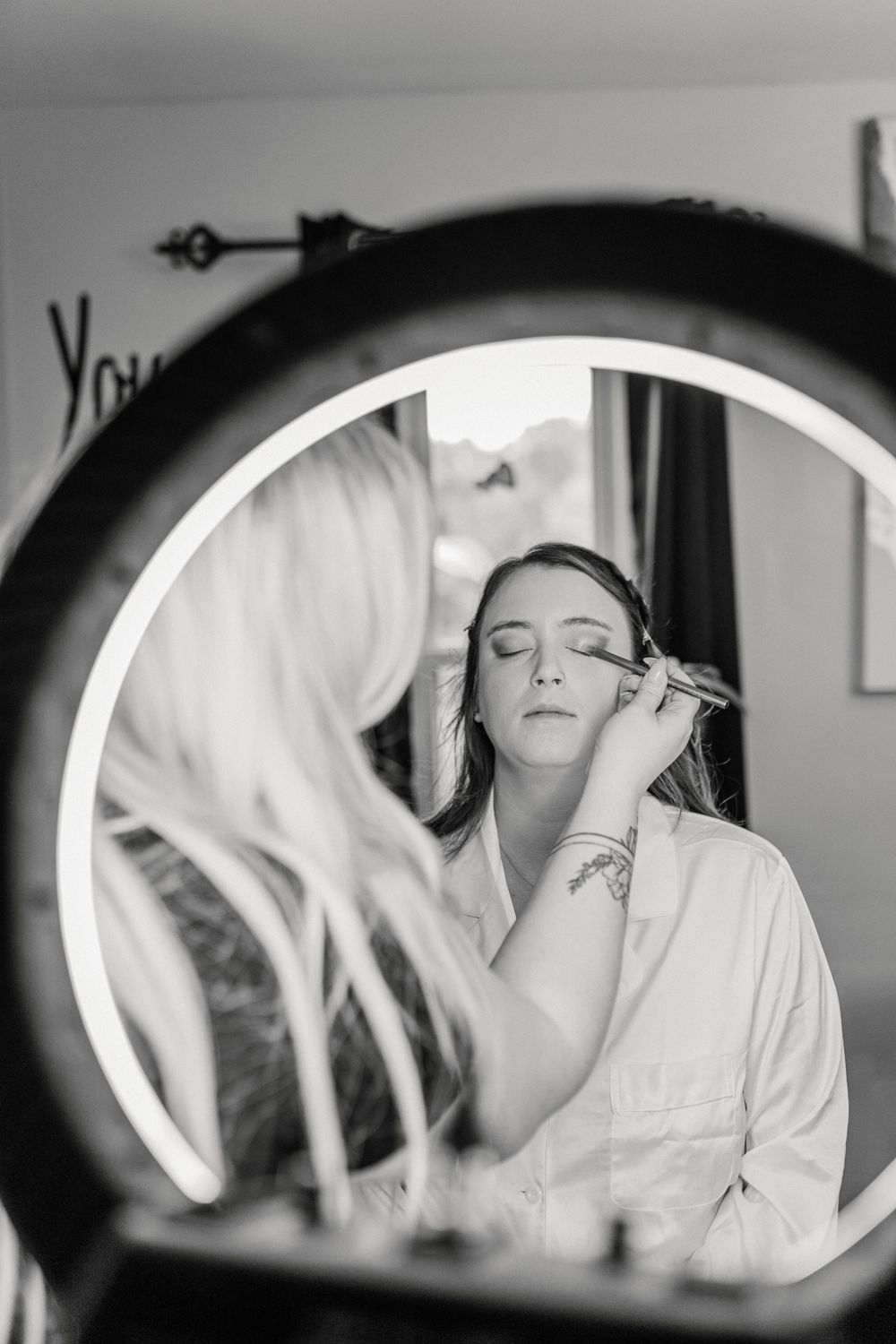 Black and white photography series showing makeup application in mirror reflection.