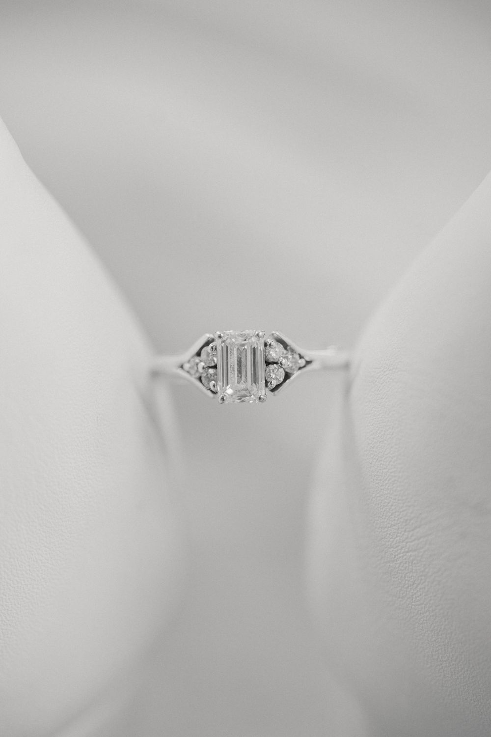 Vintage-style engagement ring with geometric details photographed in black and white.
