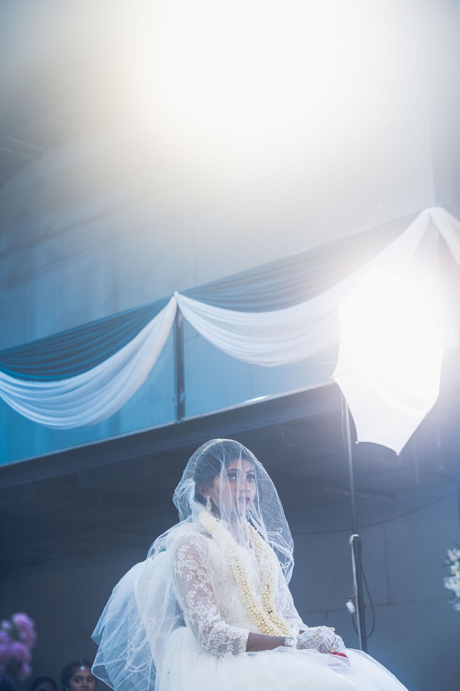 Ethereal wedding scene with white draped fabric and soft lighting creating atmospheric ambiance.