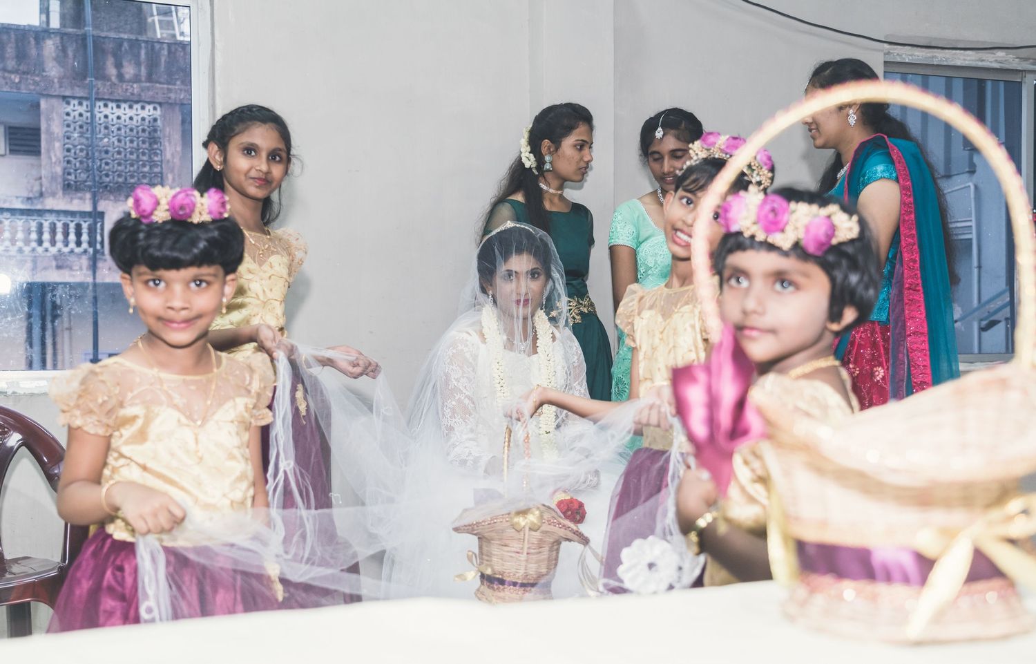 Several attendees gather at a festive celebration with decorative pink and white elements.