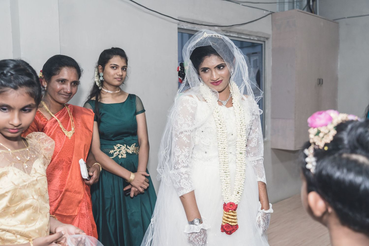 Wedding guests and bridesmaids in traditional Indian attire gather for celebrations.