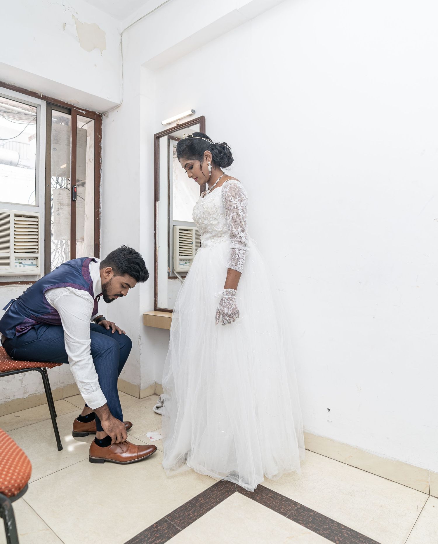 A wedding preparation scene showing final touches being made to formal attire.