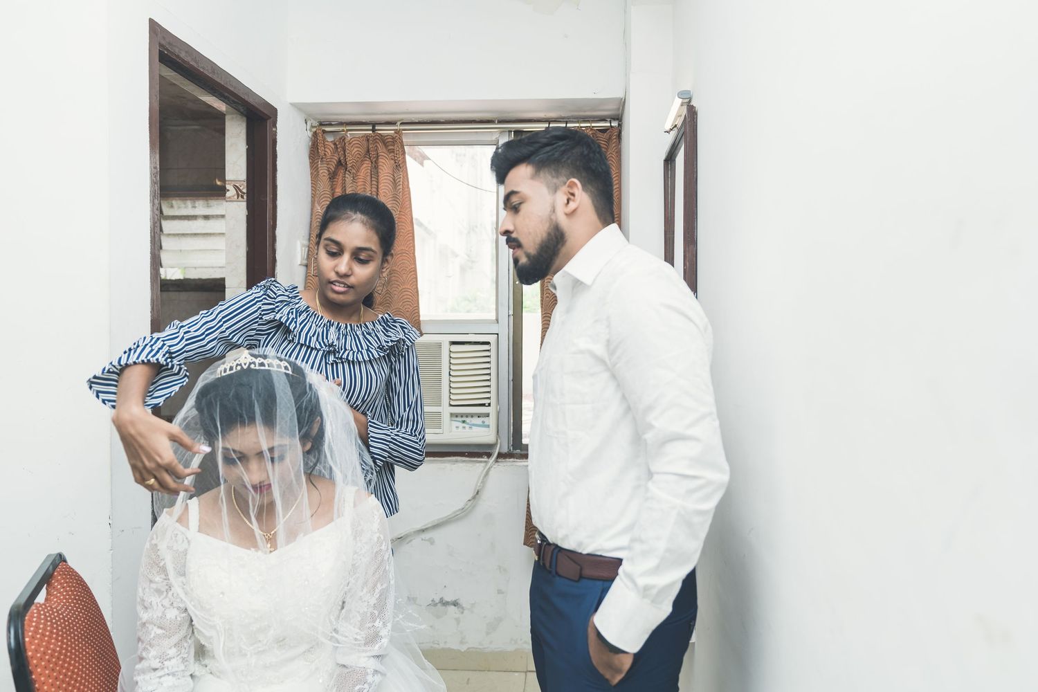 Behind the scenes moment of wedding preparations in a small room.