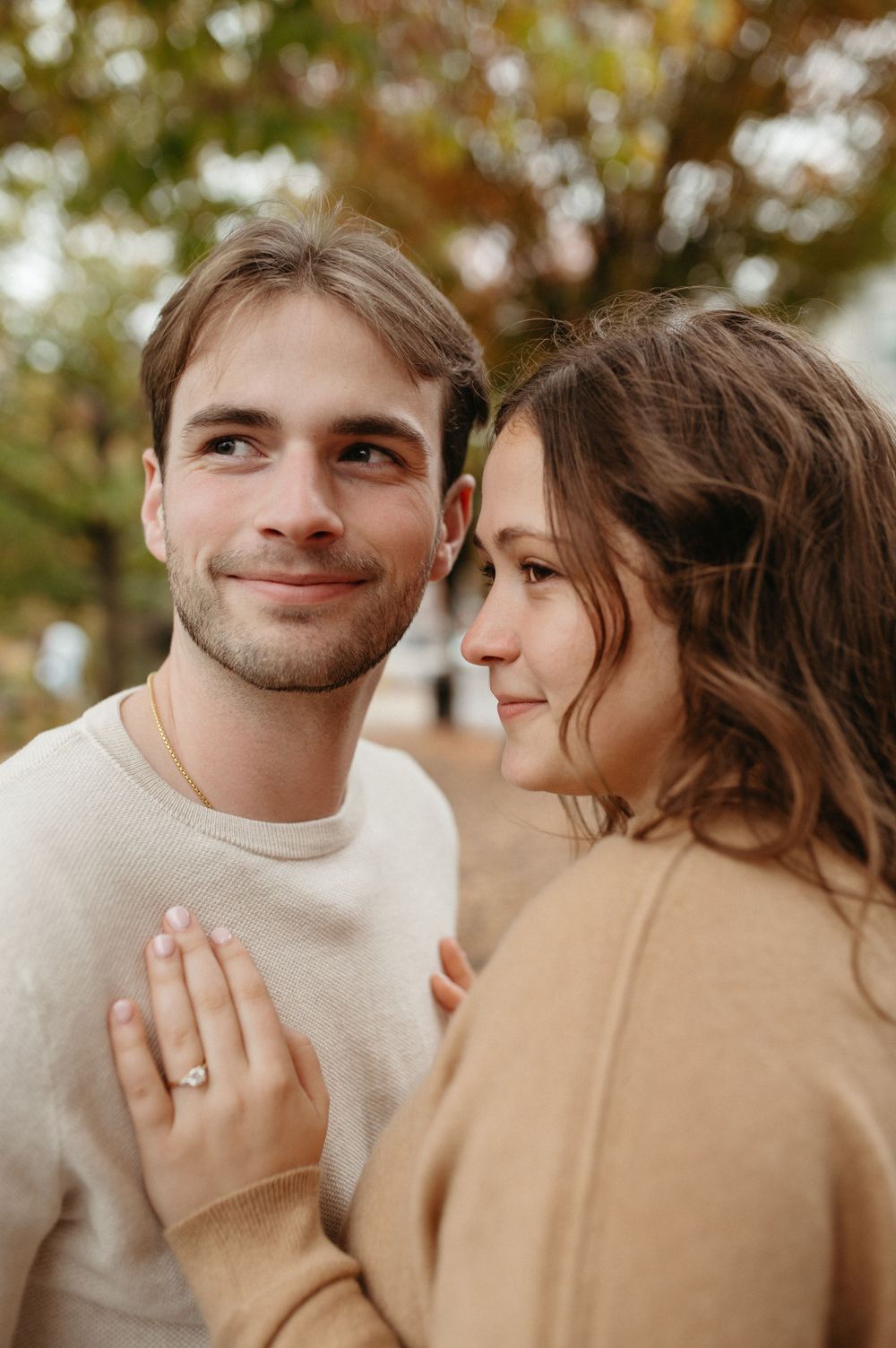 Couple sharing intimate moment during fall engagement photo session.